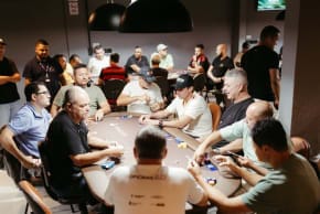 Poker players around live table.