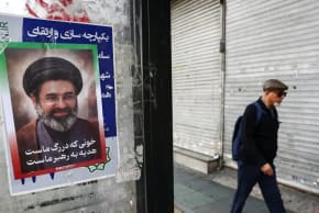 Un hombre camina junto a un cartel con una fotografía del nuevo líder supremo de Irán, Mojtaba Jamenei, en Teherán, Irán, el 22 de marzo de 2026