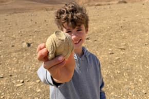 Eight-year-old Dor Wolynitz with the over 1,700-year-old statuette fragment he found in the Ramon Crater area, May 11, 2026.