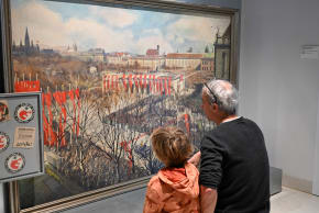 A FATHER educates his son on past crimes in front of Igo Pötsch’s March 1938 painting ‘Fahrt des Führers zur Proklamation’ in the Wien Museum.