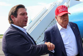 Donald Trump holds Florida Governor Ron DeSantis' hand as they speak with the media at the Dade-Collier Training and Transition Airport on the day of the opening of a temporary migrant detention center informally known as "Alligator Alcatraz" in Ochopee, Florida, US, July 1, 2025.