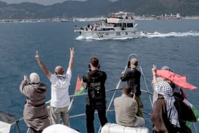La gente hace el signo de la V y se hace fotos desde un barco decorado con banderas palestinas, mientras otra embarcación con símbolos de solidaridad pasa cerca del puerto de Marmaris, Turquía, el 14 de mayo de 2026. 