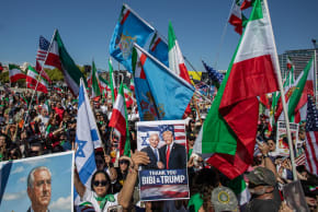 A MAN holds pictures of Reza Pahlavi, son of the former shah of Iran, while another man holds a photo of Prime Minister Benjamin Netanyahu and US President Donald Trump as people wave Iranian pre-1979 Islamic Revolution flags in front of the Federal Building in Los Angeles, California, in March 2026