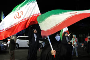 Women hold Iran's national flags during an anti-US and Israel protest at the Hafte Tir Square in Tehran on May 17, 2026.