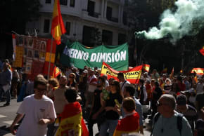 Varias personas participan en una manifestación organizada por el partido de extrema derecha español VOX contra el Gobierno del presidente Pedro Sánchez, en Madrid, España, el 23 de mayo de 2026. En las pancartas se lee «Dimisión del Gobierno» y «Somos patriotas». 