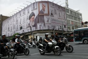 PEOPLE RIDE motorcycles near a billboard with an image of the late Iranian Supreme Leader Ayatollah Ali Khamenei, in Tehran, Iran, May 19, 2026.