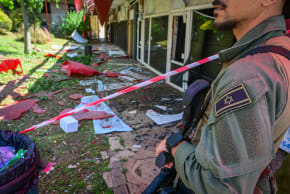 Israeli security forces and civilians at the scene where a missile fired from Lebanon toward Israel overnight caused damage in the northern Israeli city of Kiryat Shmona, May 30, 2026. 