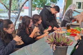 Jewish and Druze students come together and share bread and vegetables grown at a farm extension of the Amal high school in Yanuh Jat in November 2025.