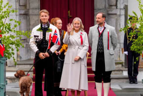 La princesa heredera de Noruega, Mette-Marit, saluda con la mano mientras, junto con el príncipe heredero Haakon y el príncipe Sverre Magnus, recibe a la comitiva infantil con motivo de la Fiesta Nacional de Noruega, en Asker (Noruega), el 17 de mayo de 2026.