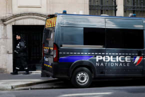 A private security member stands next to a police van. Ilustrative.