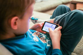  A kid plays on a phone. 