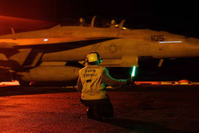 U.S. Sailors signal an F/A-18E Super Hornet on the deck of USS George H.W. Bush (CVN 77) as the aircraft carrier transits the Arabian Sea.