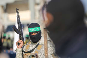 Palestinian militant group Hamas fighters secure an area before handing over two Israeli hostages to a Red Cross team in Khan Yunis.