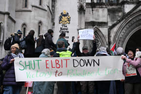 Protesters hold signs outside the Royal Courts of Justice, after High Court judges ruled the British government’s decision to designate pro‑Palestinian group Palestine Action as a terrorist organisation unlawful, in London, Britain, February 13, 2026.