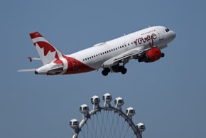 An Air Canada Airbus A319 departs from Harry Reid International Airport en route to Toronto with the High Roller Ferris wheel in the background on March 11, 2026 in Las Vegas, Nevada. 