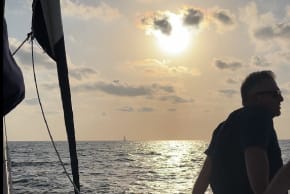 A man sits aboard one of the boats belonging to the Derech Hayam (Via Maris) yachting club and school. August, 2026.