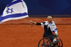 GUY SASSON proudly waves the Israeli flag after winning the bronze at the 2024 Paralympics in Paris; illustrative