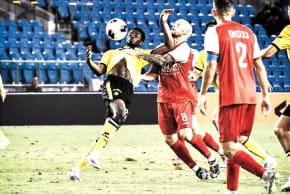 Bnei Sakhnin midfielder Modestas Vorobjovas (in yellow) and Maccabi Netanya’s Aziz Ouattara (8) vie for the ball during their teams’ season-opening goalless draw. 