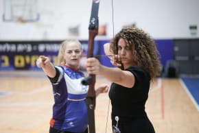 A woman draws her bow at a Warriors of Israel event.