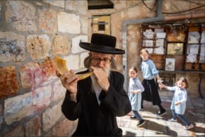 An ultra-Orthodox man blows a shofar ahead of Rosh Hashanah in Mea She’arim in Jerusalem in August