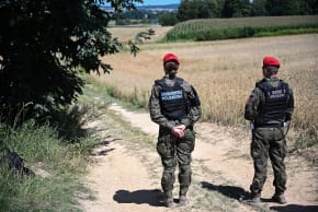 Police officers of the "Military Gendarmerie" stand guard in an area near the village of Tarnawa-Kolonia, eastern Poland, 30 July 2026, where a flying object hit the ground and exploded in the early hours of the day, the fire service reported.