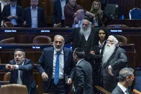 Shas chairman Aryeh Deri, government ministers and members of Knesset attend a plenum session and a vote on a bill to freeze arrests of haredi draft evaders at the assembly hall of the Knesset, the Israeli parliament in Jerusalem, July 14, 2026.