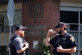 Police officers talk near the scene of a shooting where a police officer was shot outside a Yom Kippur gathering at Sons of Jacob Synagogue in Belleville, Ontario, Canada, September 21, 2026.