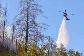 A firefighting helicopter makes a water drop in the path of the Lucas Fire burning near Upper Lake, a community in Lake County, California, US, September 12, 2026.