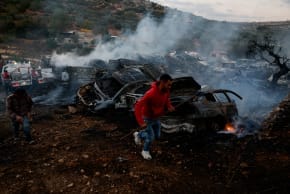 A man holds a fire flapper near destroyed cars, which Palestinians say were burned by Israeli settlers, in Yabrud, near Ramallah, in the West Bank, October 4, 2026.
