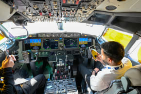 (Illustrative) People sit in the cockpit of a FlyDubai 737 Max on display at Al-Maktoum International Airport during the Dubai Airshow 2025 in Dubai on November 20, 2025. 