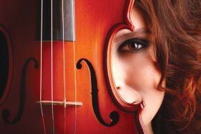 ILLUSTRATIVE: A woman's face is pictured behind a violin. 