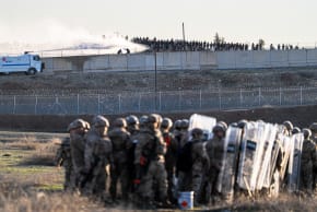 Turkish security forces line up in the buffer zone as Turkish police use water cannon to disperse Syrian supporters who gather at the border, across from the northern Syrian town of Qamishli, January 20, 2026