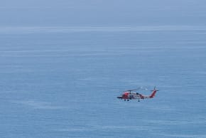 A U.S. Coast Guard Helicopter flies over the Pacific Ocean on August 21, 2026 in Malibu, California.