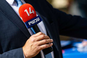  reporter holds a microphone of Israel’s Channel 14 news at a polling station during the Likud primary elections in Jerusalem, August 17, 2026.