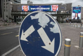 A road sign stands in front of a large billboard featuring Prime Minister Benjamin Netanyahu of the Likud party and leader of the centrist Yashar party, Gadi Eisenkot, in Ramat Gan, October 26, 2026