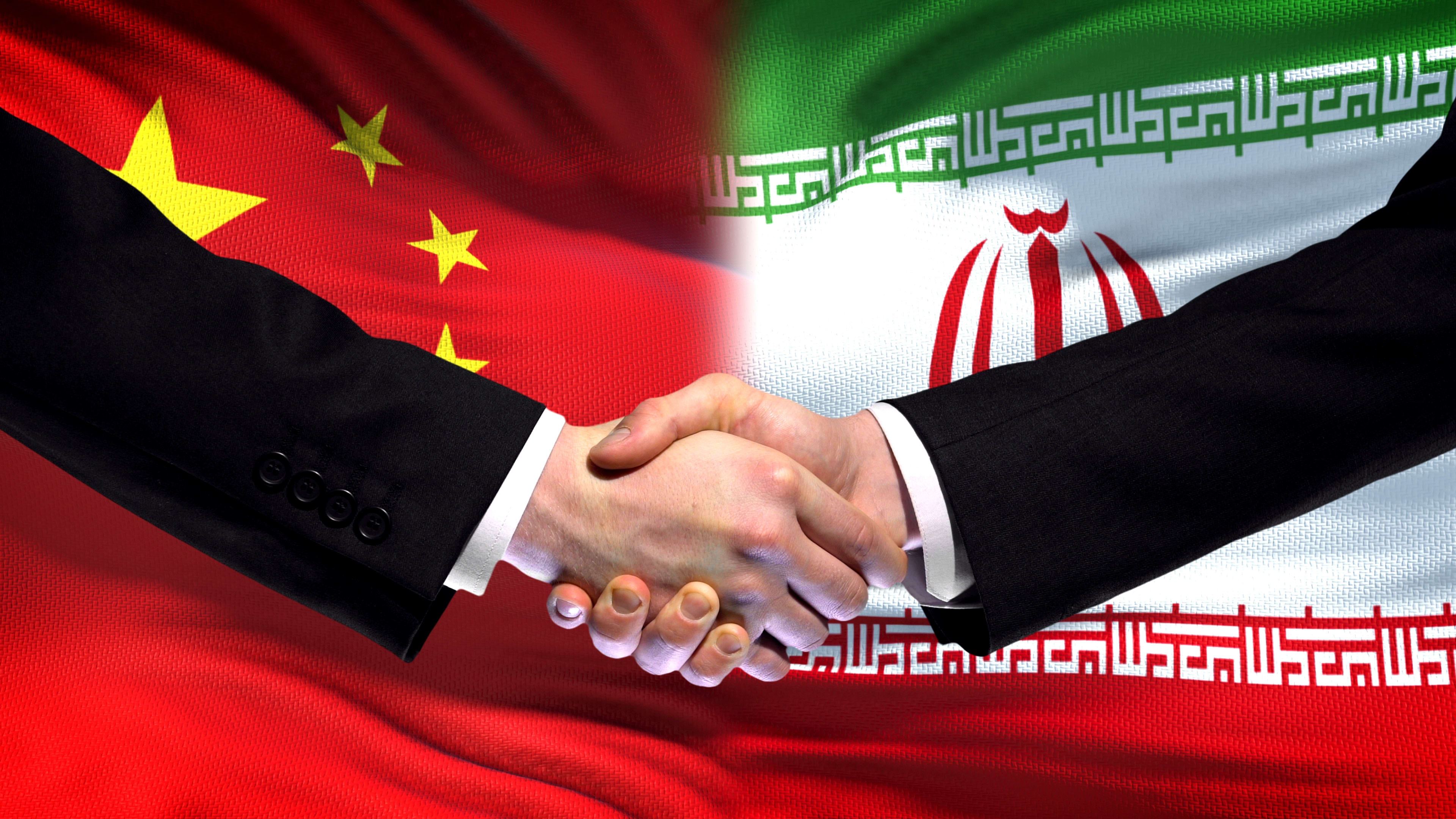 An illustration of a handshake over the backdrop of a Chinese and Iranian flag. (photo credit: Motortion Films/Shutterstock)