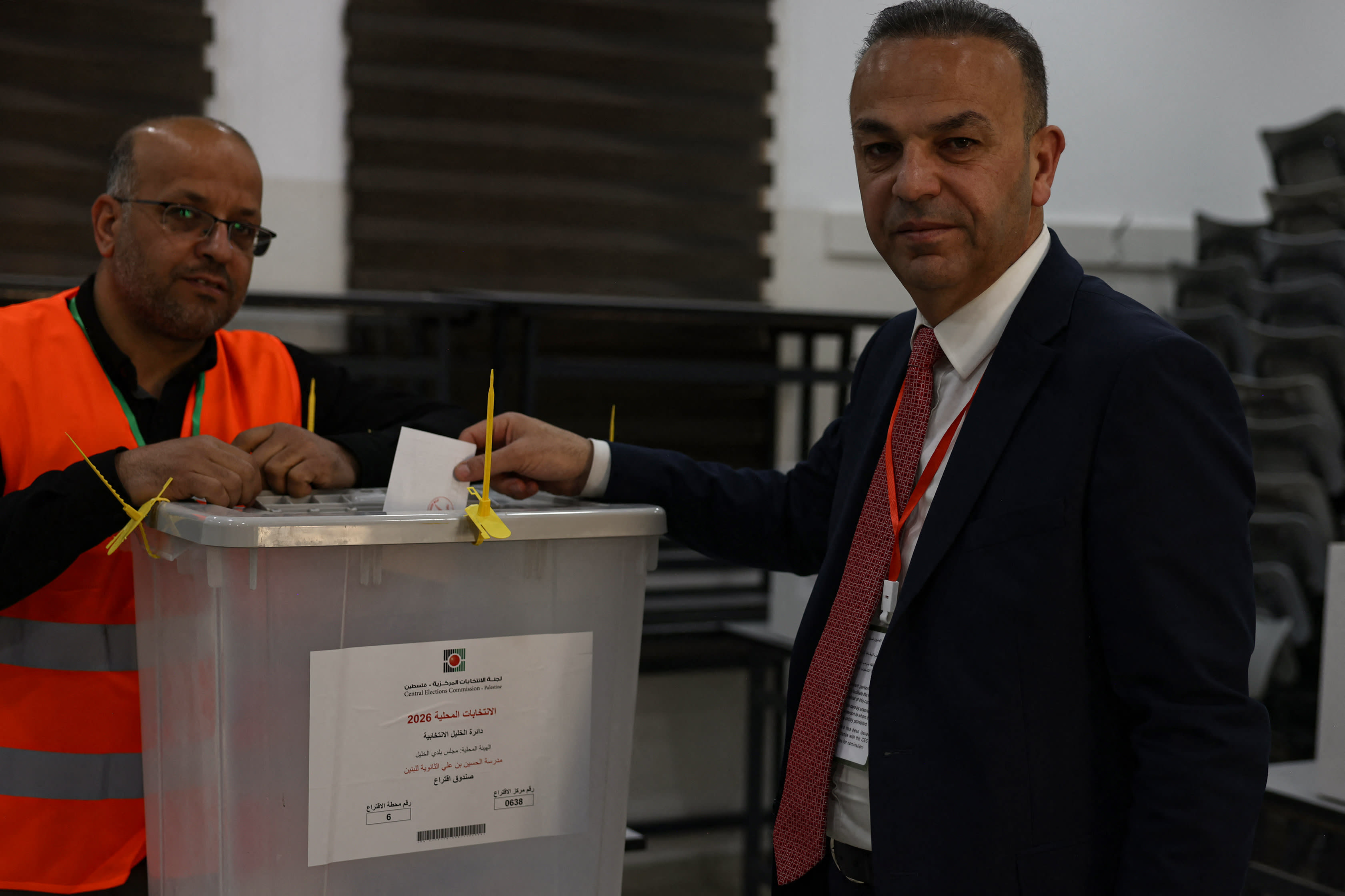 Yousef al-Jaabari (R), candidate of the Palestinian Fatah movement, casts his ballot at a polling station during municipal elections in the West Bank city of Hebron on April 25, 2026.  (photo credit:  HAZEM BADER / AFP via Getty Images)