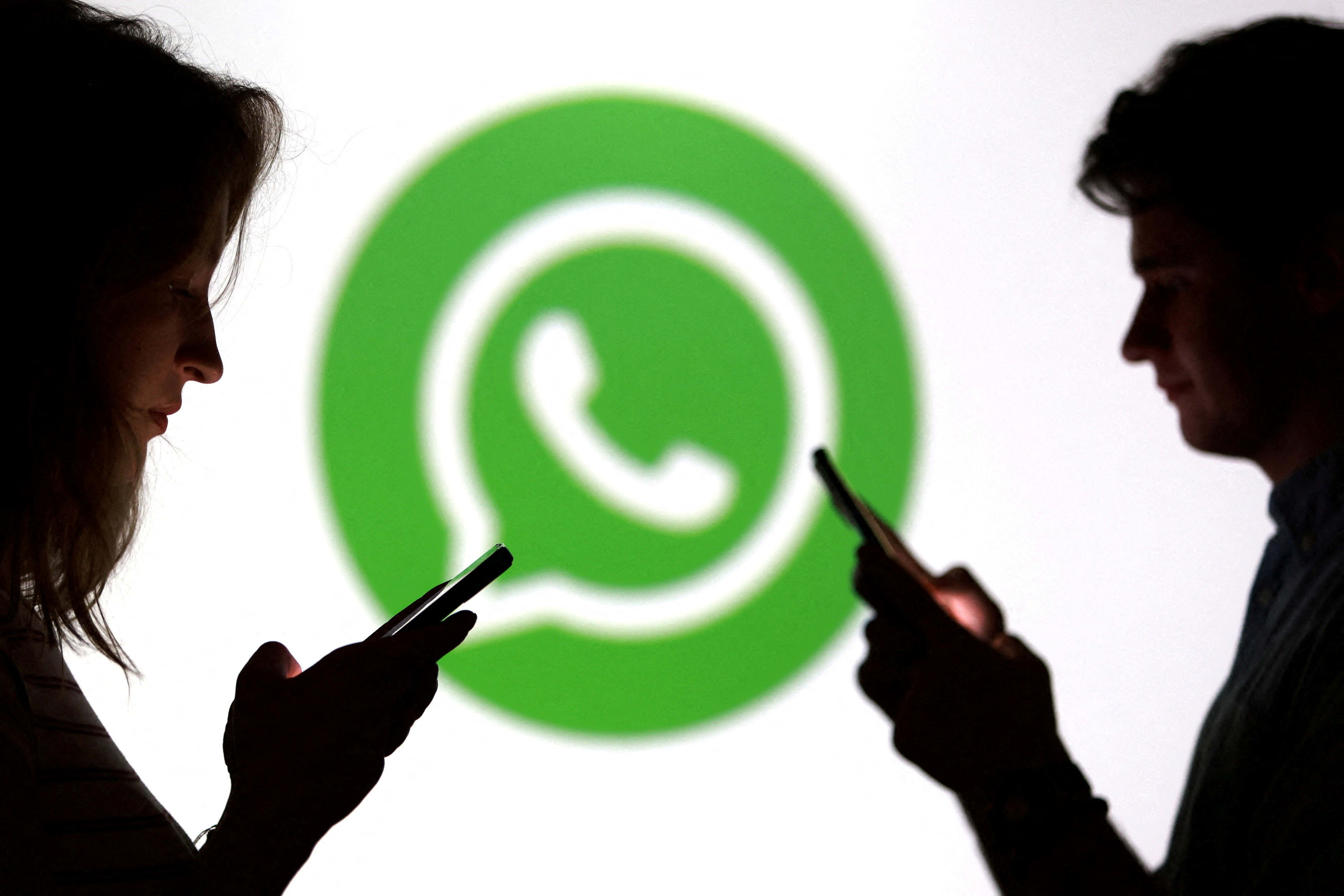 Teenagers pose for a photo while holding smartphones in front of a Whatsapp logo in this illustration taken September 11, 2025. (photo credit: REUTERS/DADO RUVIC/ILLUSTRATION/FILE PHOTO)