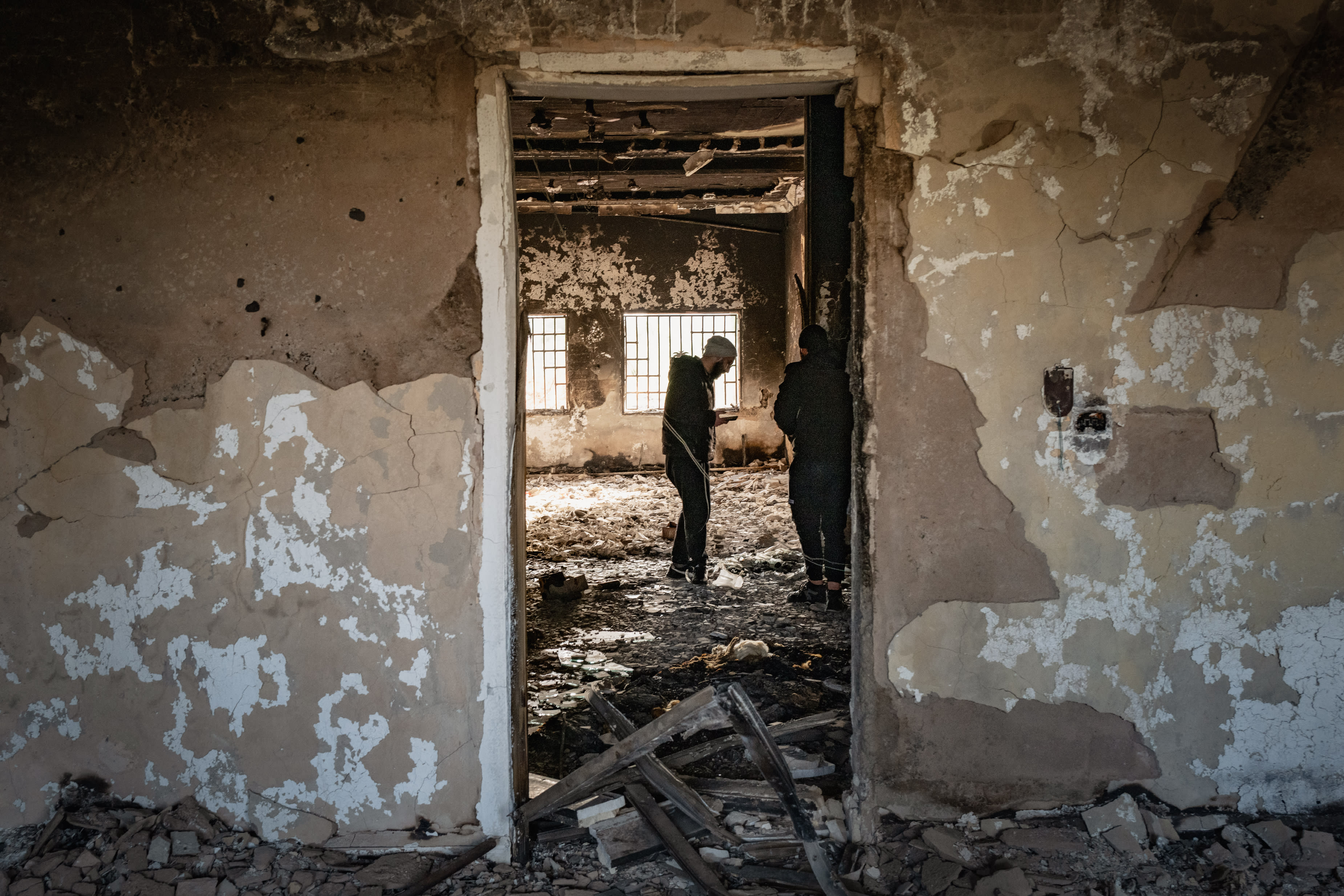 PEOPLE STAND inside a destroyed home in Sweida, Syria, that had been targeted in a massacre of Druze villages in the area by Syrian forces. (photo credit: Elke Scholiers/Getty Images)