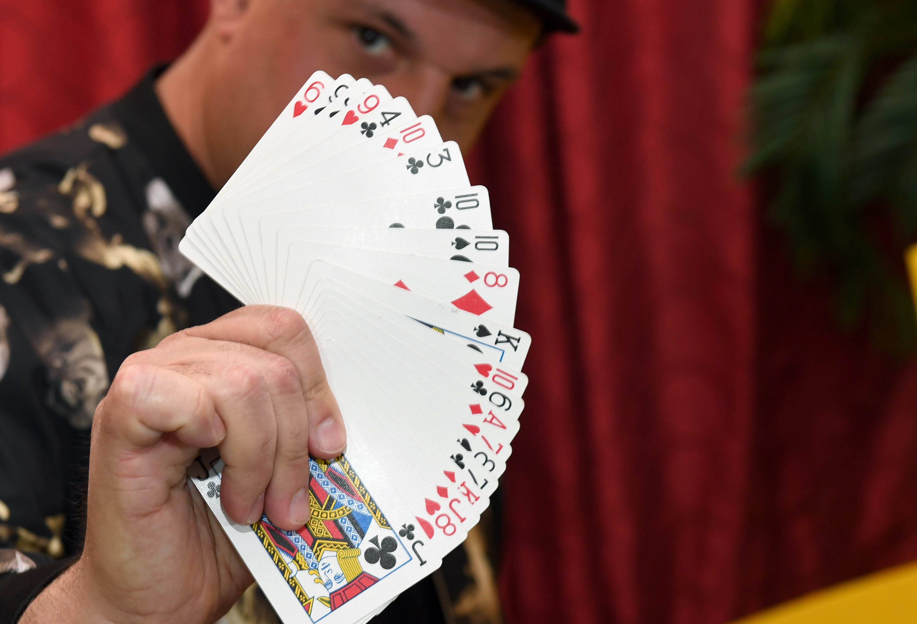 Creative director/magician Douglas "Lefty" Leferovich fans out a deck of cards before teaching magic tricks on Facebook Live with magician/comedian Murray SawChuck from SawChuck