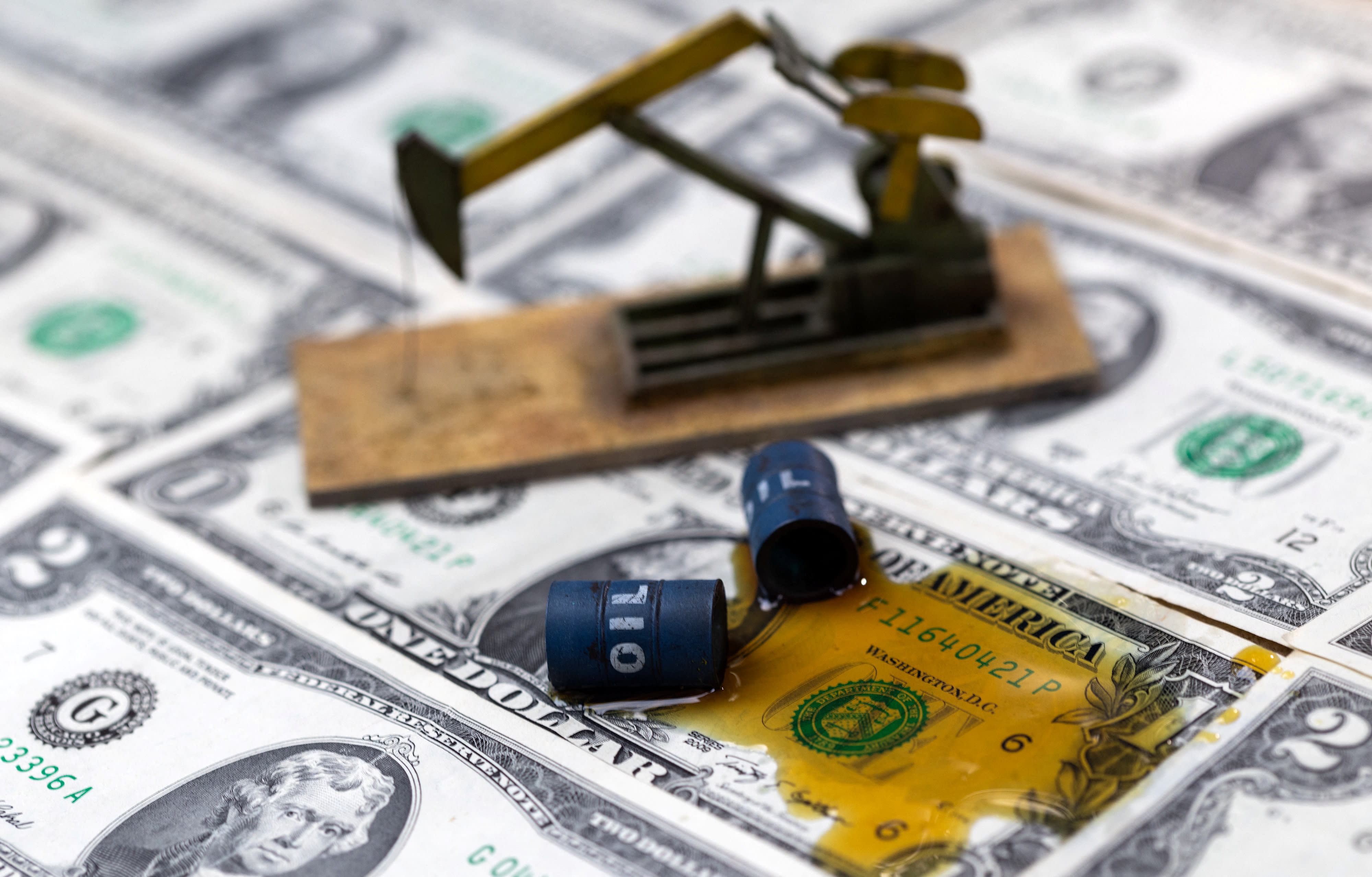  Oil, miniatures of oil barrels, oil pump jack and U.S. dollar banknote are seen in this illustration taken, June 6, 2023. (photo credit: DADO RUVIC/REUTERS)