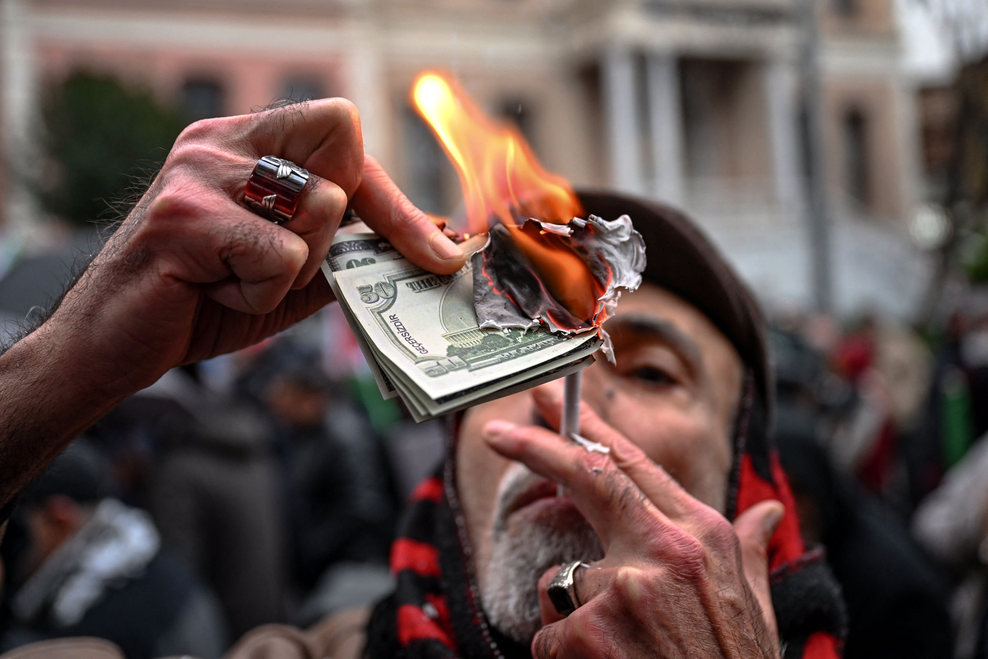 A protester burns fake US dollars during a pro-Iranian regime demonstration in front of the Iranian consulate in Istanbul, on January 18, 2026. (photo credit: Ozan Kose/AFP via Getty Image)