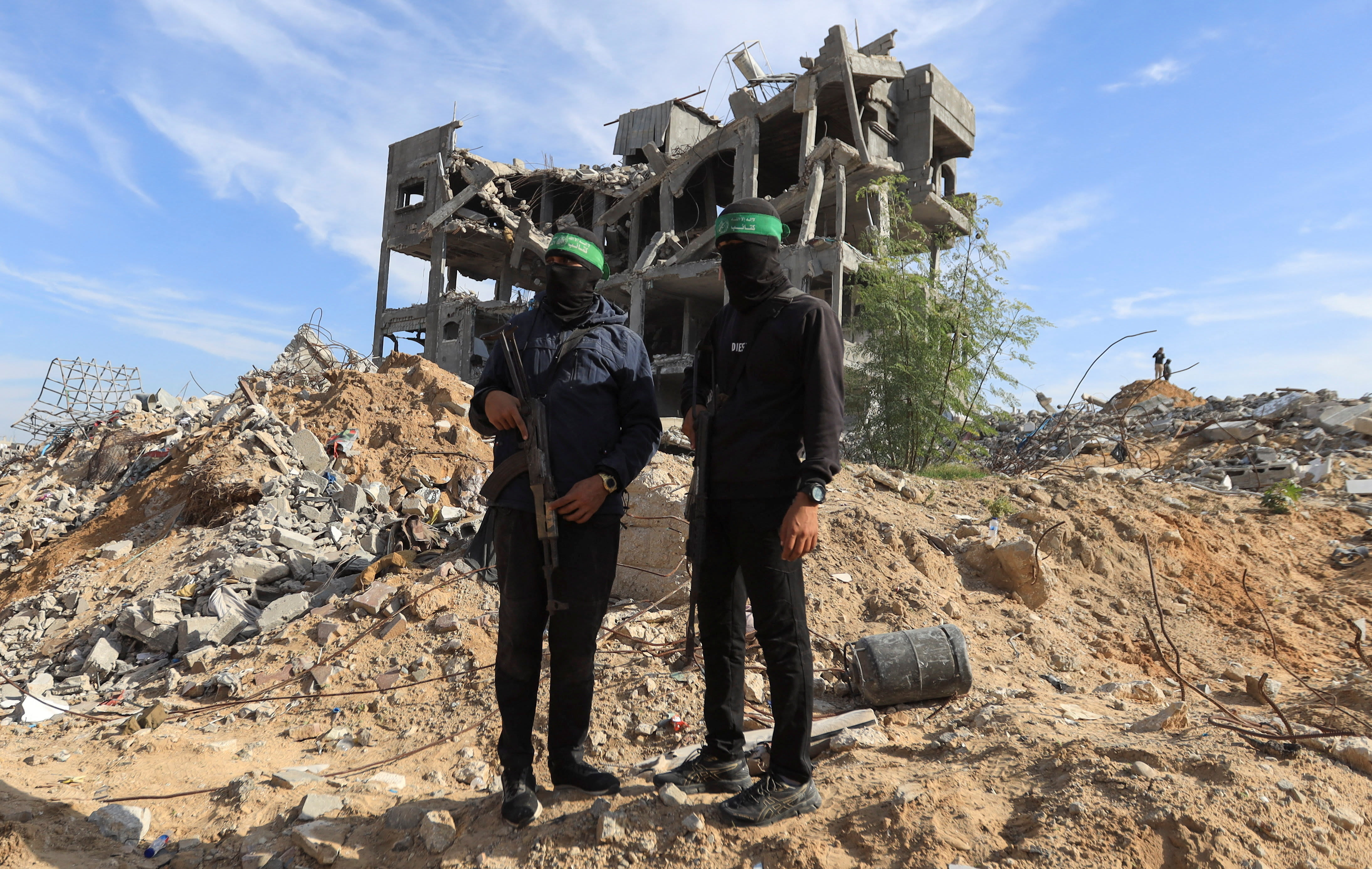 Palestinian Hamas terrorists stand guard at a site as Hamas says it continues to search for the bodies of deceased hostages, in Beit Lahiya in the northern Gaza Strip December 3, 2025. (photo credit: REUTERS/STRINGER)