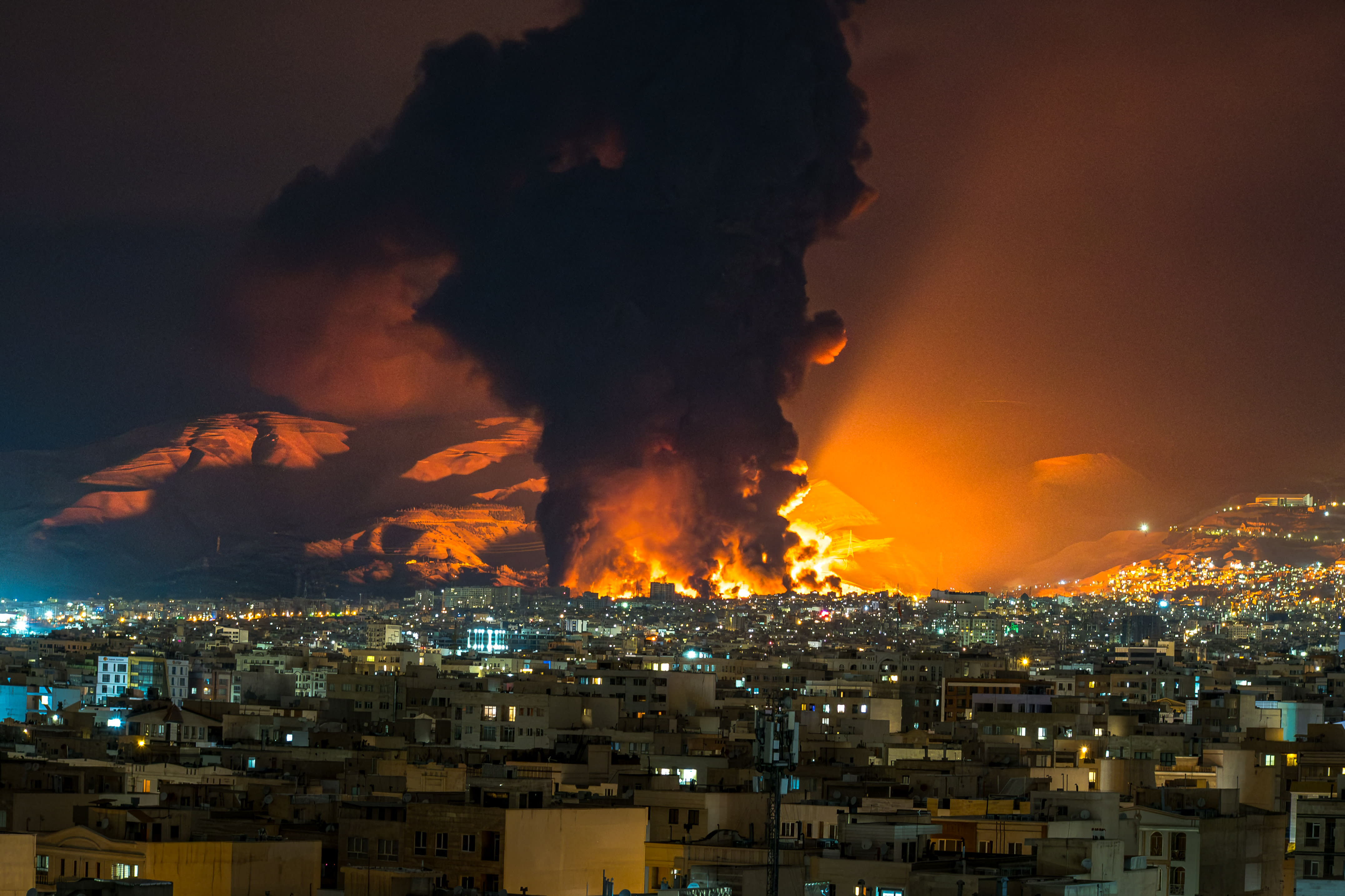 Smoke and flames rise at the site of airstrikes on an oil depot in Tehran on March 7, 2026.  (photo credit: Sasan / Middle East Images / AFP via Getty Images)