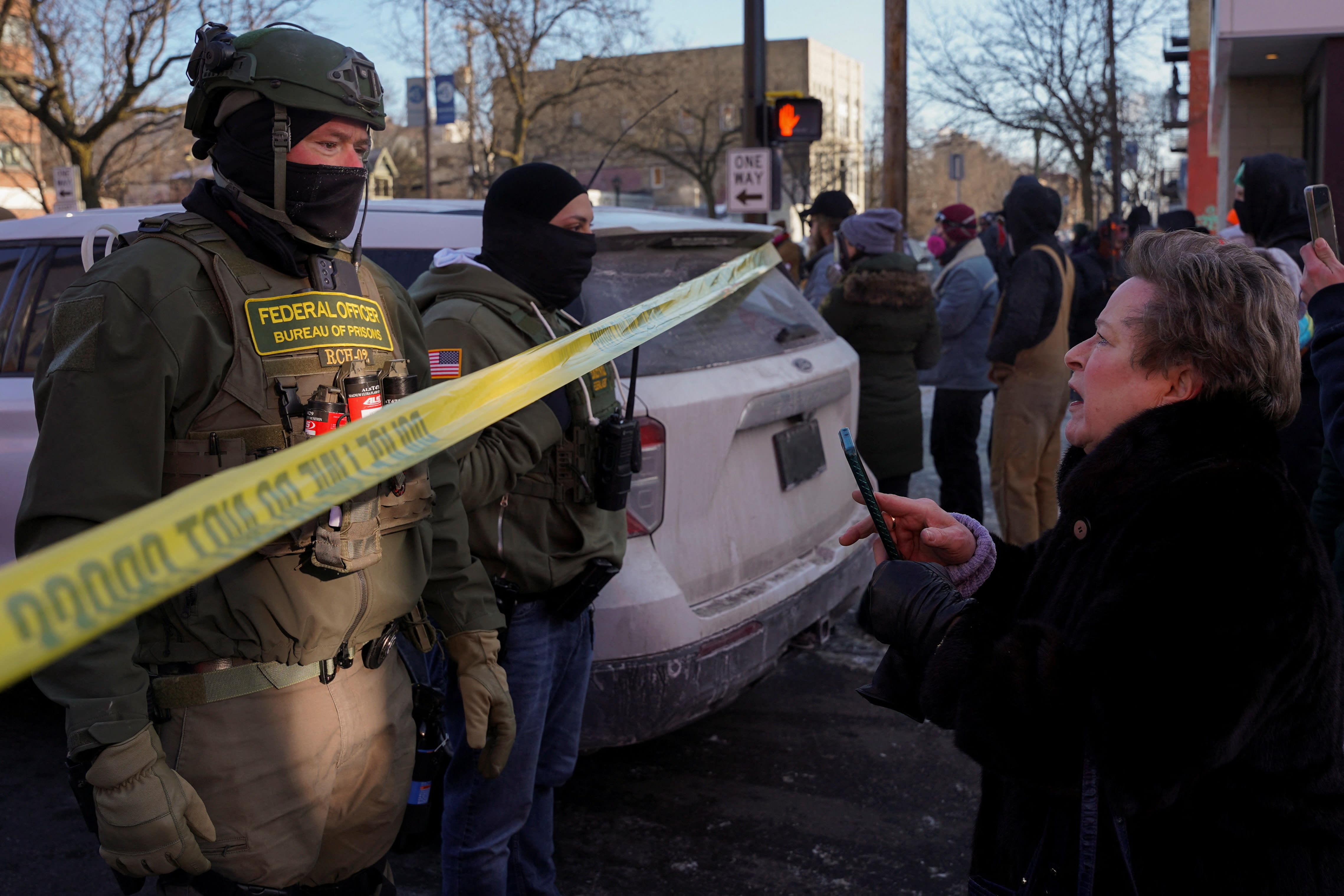 Federal agents stand behind police tape as people gather near the site where a man identified as Alex Pretti was fatally shot by federal agents trying to detain him, in Minneapolis, Minnesota, US, January 24, 2026. (photo credit: Seth Herald/Reuters)