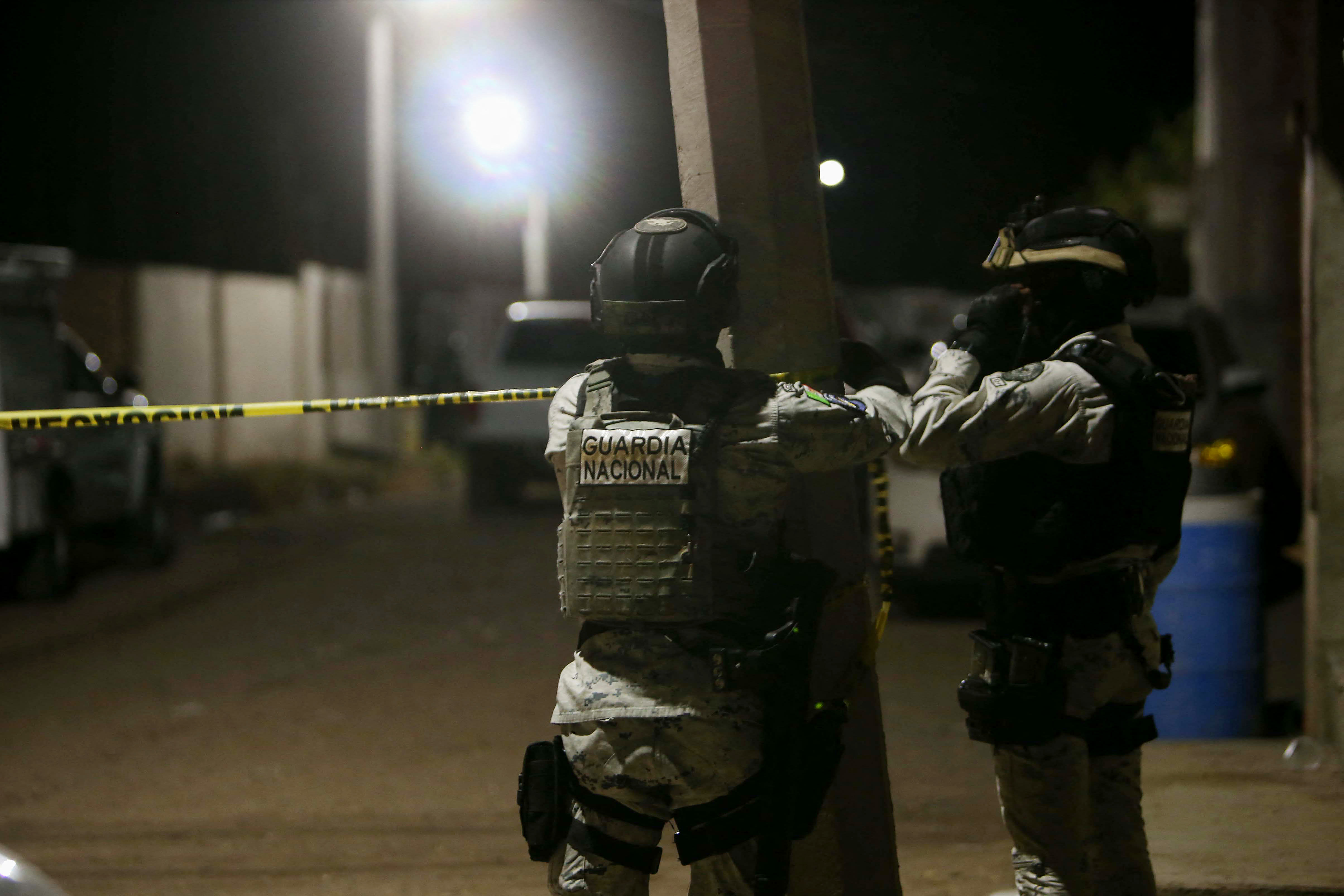 Members of the National Guard install a yellow police line at the crime scene where at least 11 people were killed and 12 more wounded during an armed attack at a football field in Salamanca, Guanajuato state, Mexico, on January 25, 2026.  (photo credit: Mario Armas / AFP via Getty Images)