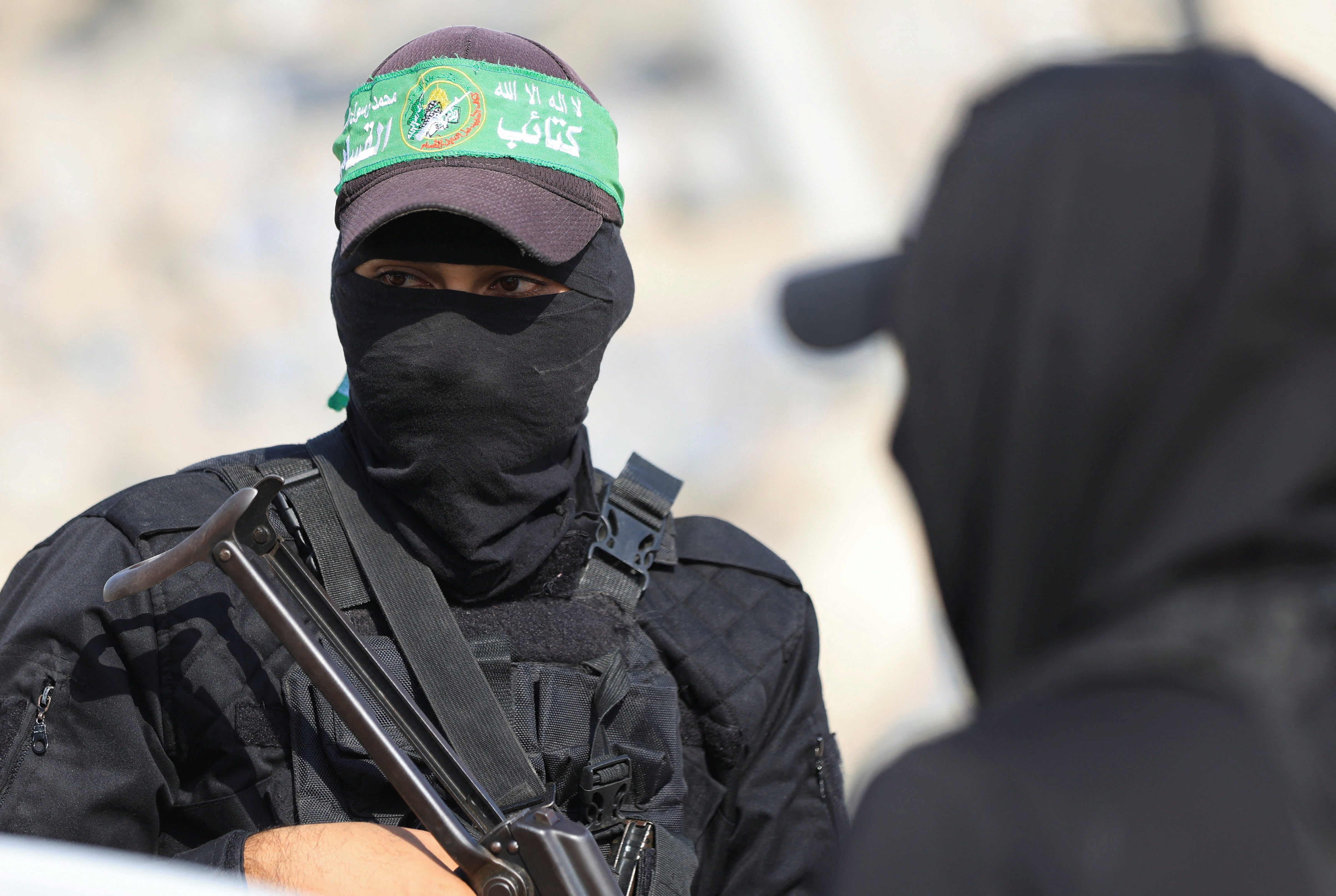 Hamas terrorists look on as they escort members of the Red Cross towards an area within the so-called "yellow line" to which Israeli troops withdrew under the ceasefire in Gaza City November 12, 2025. (photo credit: REUTERS/DAWOUD ABU ALKAS)