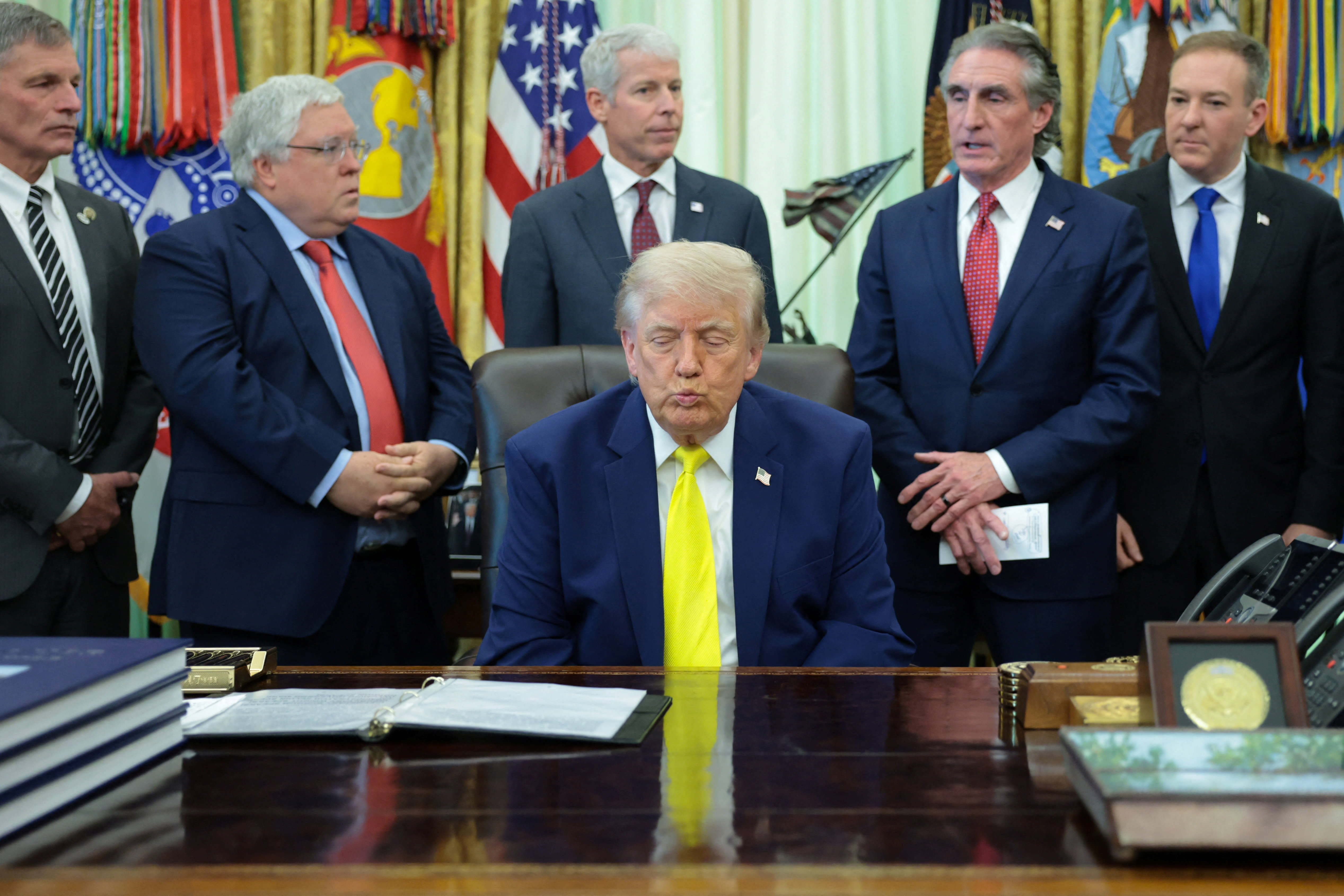 US President Donald Trump reacts as he and members of his administration deliver remarks to reporters on the Trump administration