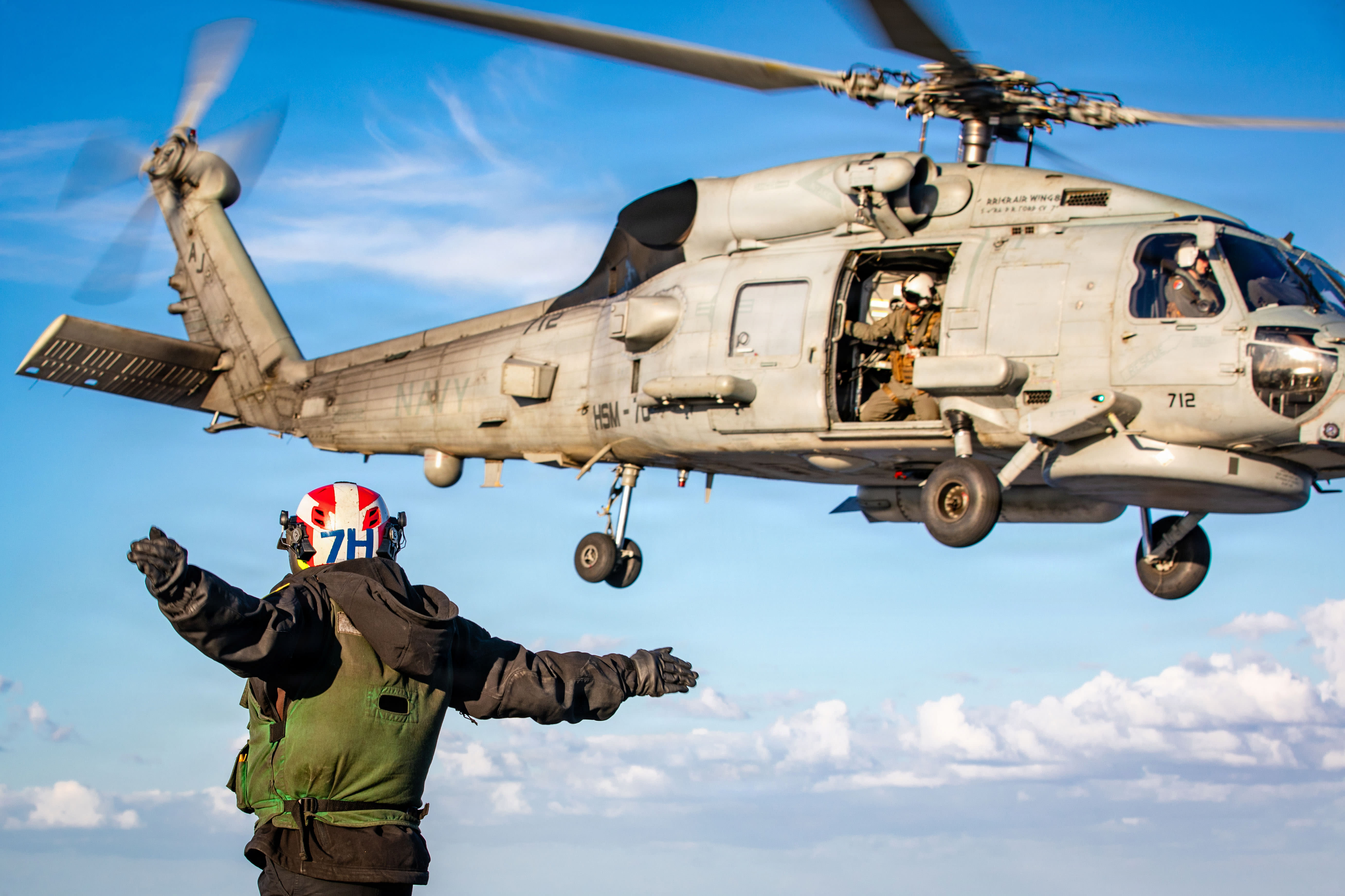 U.S. Sailor signals the launch of an MH-60R Sea Hawk helicopter, attached to Helicopter Maritime Strike Squadron 70, on the flight deck of the world’s largest aircraft carrier, USS Gerald R. Ford (CVN 78). (photo credit: U.S. Navy via Getty Images)