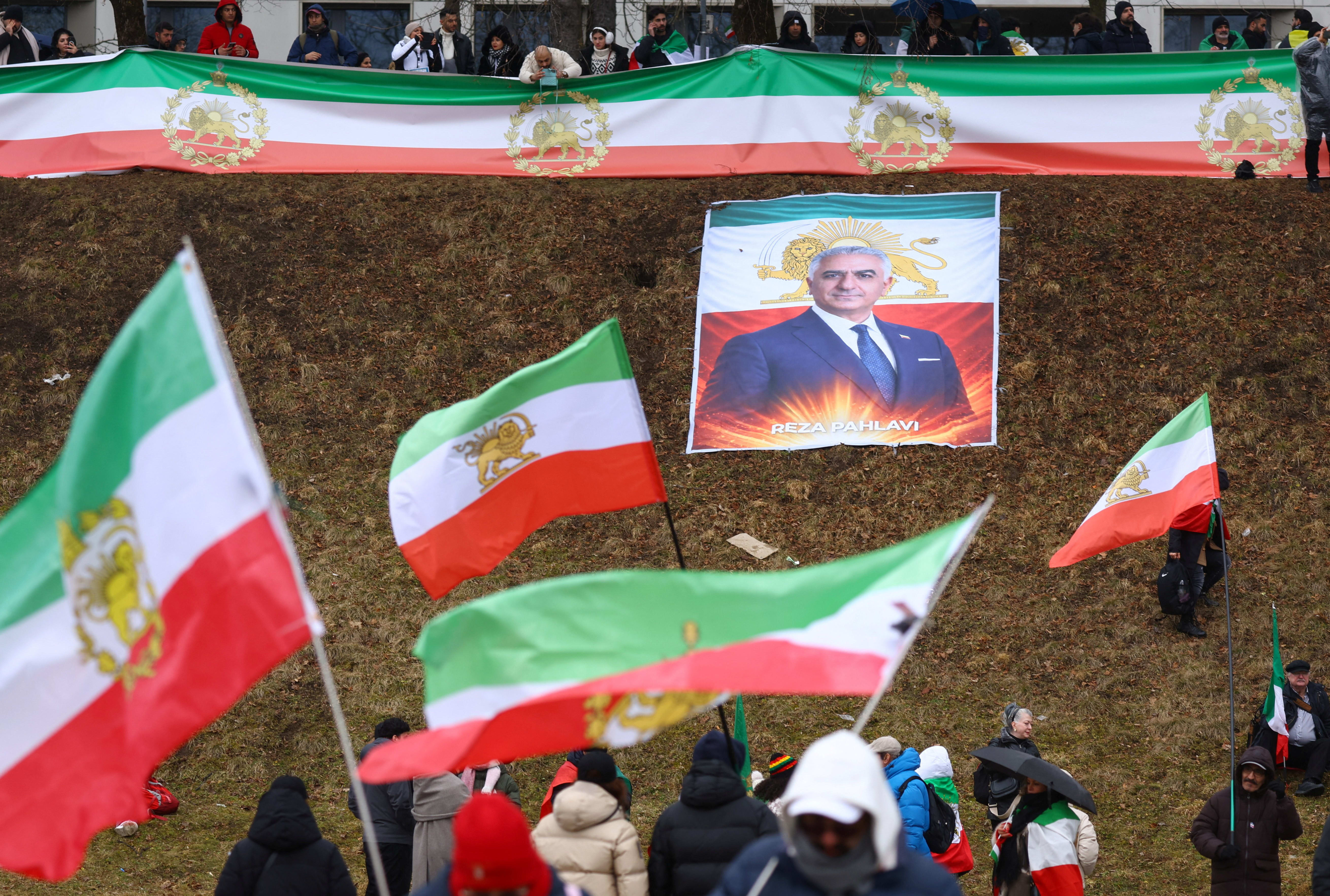 PROTESTERS HOLD ‘Lion and Sun’ pre-Iranian Revolution national flags, near an image of Reza Pahlavi. (photo credit: THILO SCHMUELGEN/REUTERS)